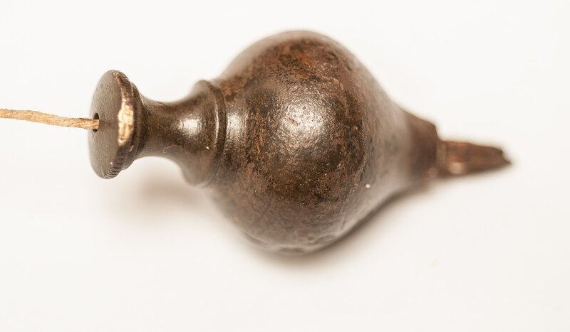 A 17th C. small bronze and iron plumb bob. 