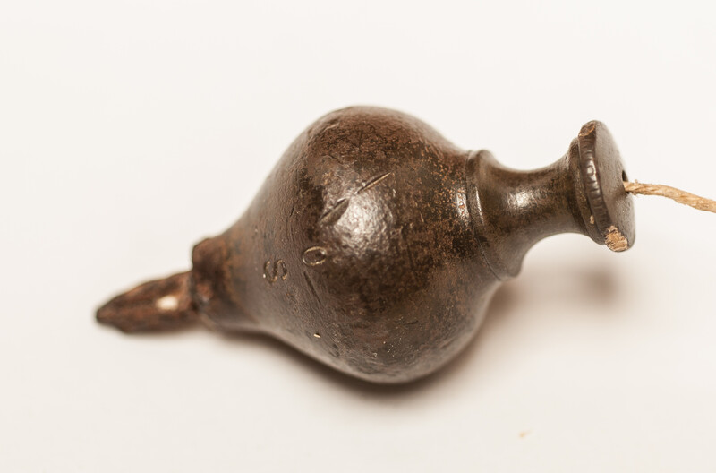 A 17th C. small bronze and iron plumb bob. 