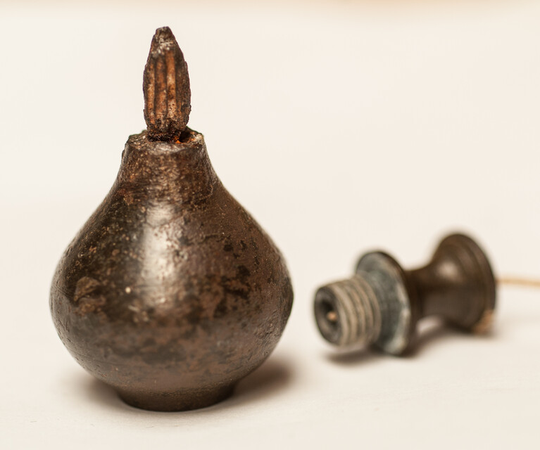 A 17th C. small bronze and iron plumb bob. 