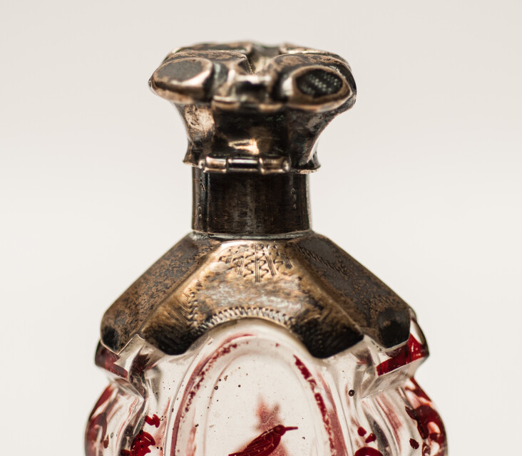 A 19th C cold enamel painted perfume bottle with a silver cap.