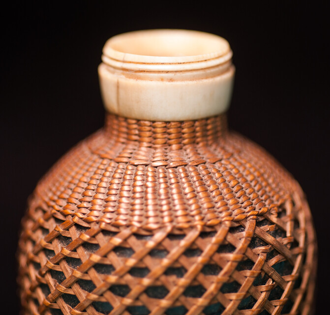 A 19th C perfume bottle covered with artful straw decoration