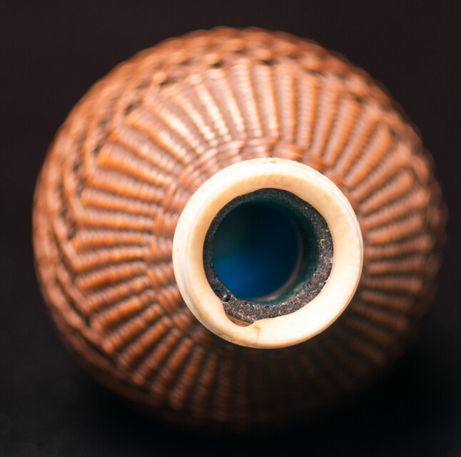 A 19th C perfume bottle covered with artful straw decoration