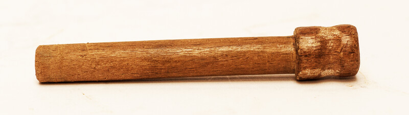 A copper toy window spout with a wooden stamper.