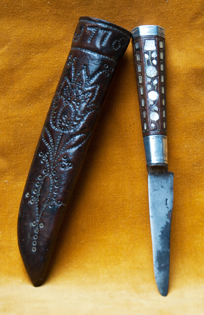 A Dutch knife with silver mountings  and mother of pearl decoration in its leather sheath dated 1776.