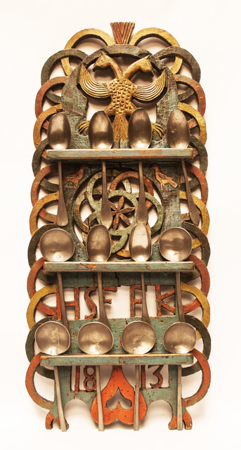 A Dutch spoonrack with 12 pewter spoons and dated 