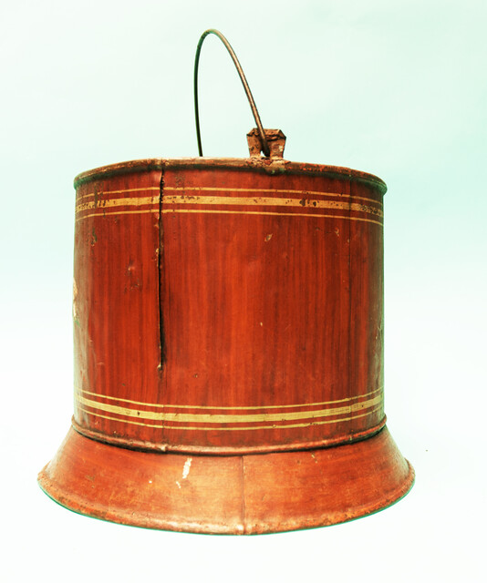 A painted metal bucket, possibly a wine-cooler.