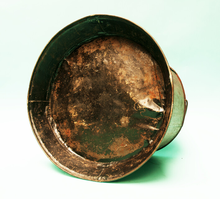 A painted metal bucket, possibly a wine-cooler.