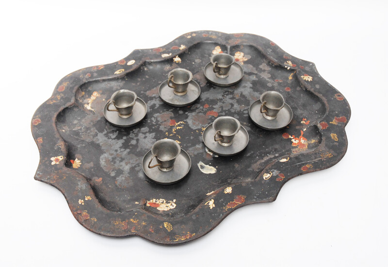 A pewter toy tea service consisting of six cup and saucers.