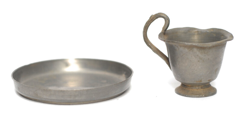 A pewter toy tea service consisting of six cup and saucers.