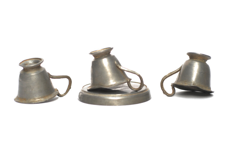 A pewter toy tea service consisting of six cup and saucers.