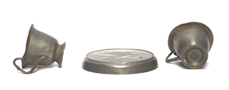 A pewter toy tea service consisting of six cup and saucers.