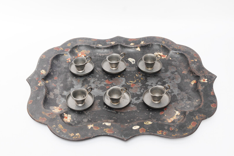 A pewter toy tea service consisting of six cup and saucers.