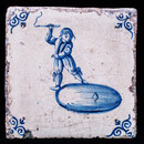 A rare early seventeenth century Delft blue tile with a boy whipping a top.