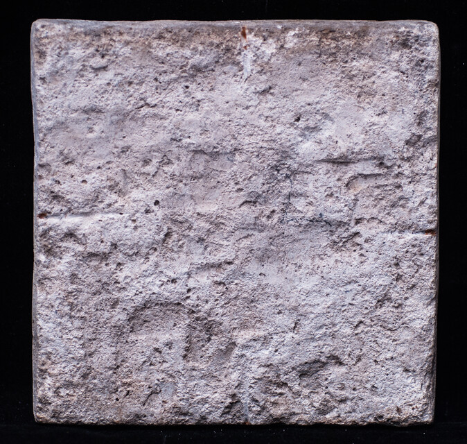 A rare early seventeenth century Delft blue tile with a boy whipping a top.