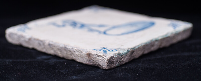 A rare early seventeenth century Delft blue tile with a boy whipping a top.
