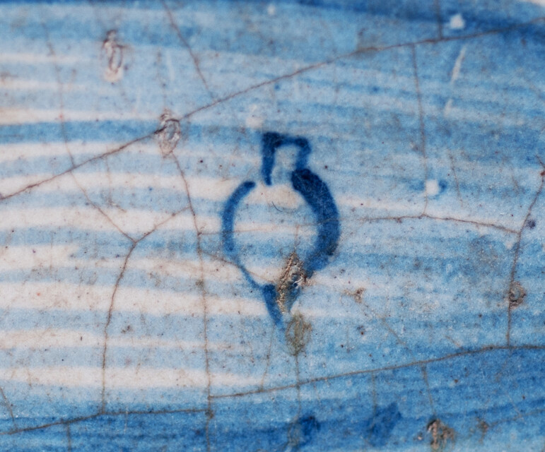 A rare early seventeenth century Delft blue tile with a boy whipping a top.