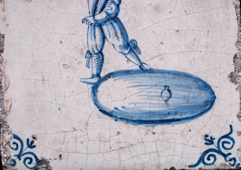 A rare early seventeenth century Delft blue tile with a boy whipping a top.