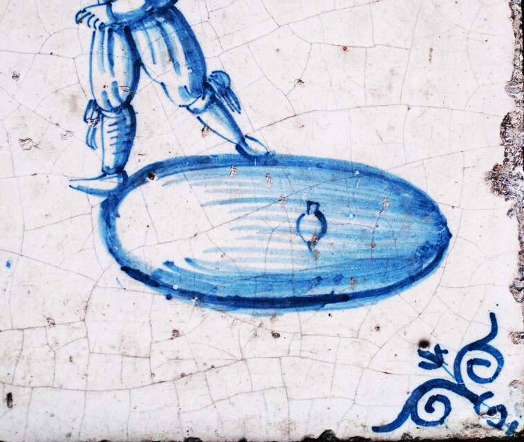 A rare early seventeenth century Delft blue tile with a boy whipping a top.