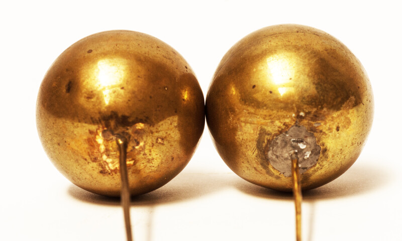 A set of brass head decorations from the traditional catholic dress of Zuid-Beveland. 
