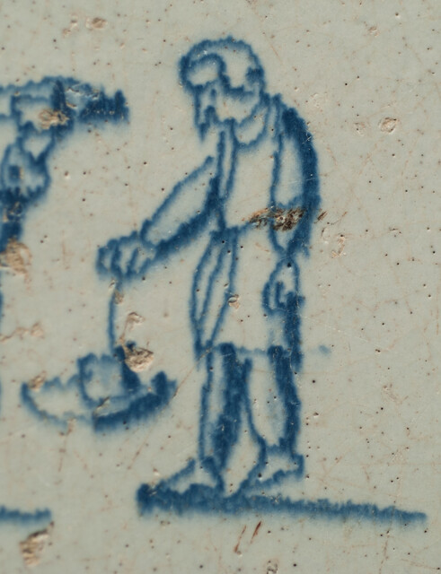 A seventeenth century Delft blue tile with two boys playing with their hats.