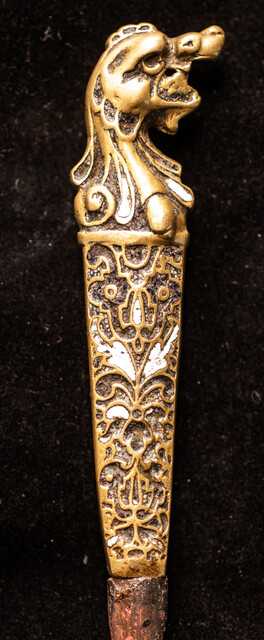 A sixteenth century European knife with a brass handle and enamel decorations.