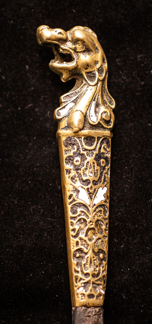 A sixteenth century European knife with a brass handle and enamel decorations.