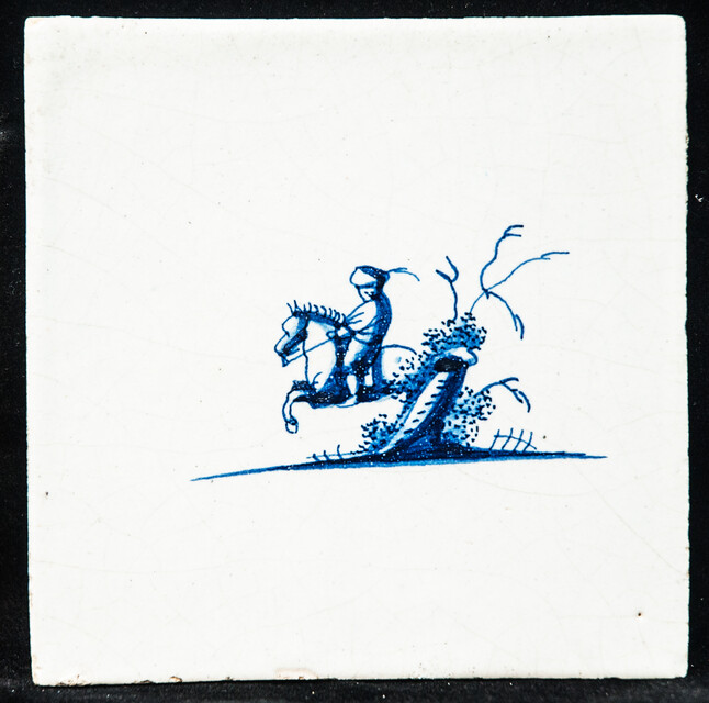 A small 17th C. Delft blue tile with a man on a horse.