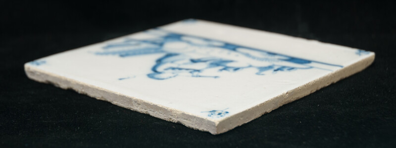 An 18th C. Delft blue tile with a hobo player.