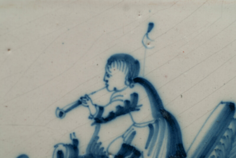 An 18th C. Delft blue tile with a hobo player.