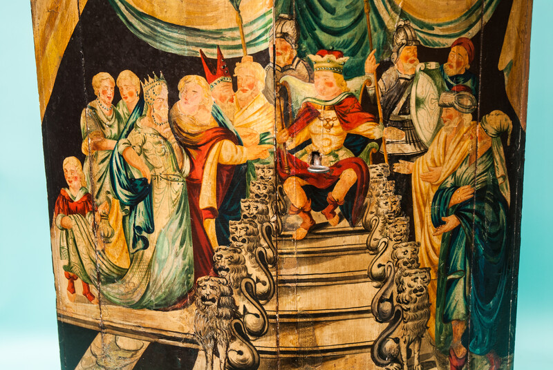 An 18th C. hanging corner cabinet from Ameland painted with a scene of King Solomon on his lion throne.