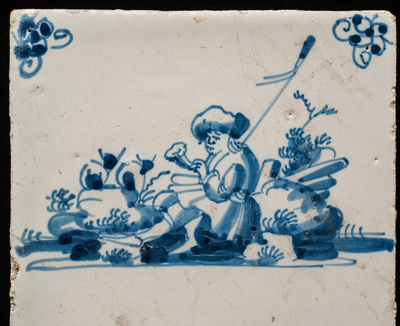 An 18th century Delft blue tile of a shepherd playing a shawm.