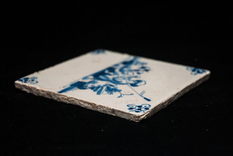 An 18th century Delft blue tile of a shepherd playing a shawm.