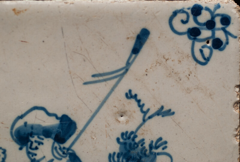 An 18th century Delft blue tile of a shepherd playing a shawm.