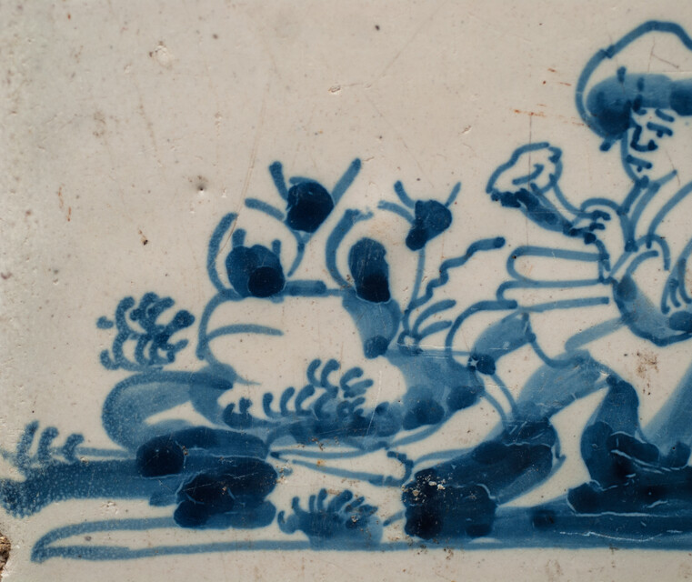 An 18th century Delft blue tile of a shepherd playing a shawm.