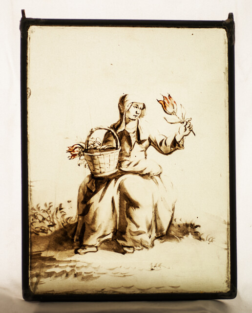 An 18th century Dutch stained glass panel in a lead frame showing a girl selling tulips.