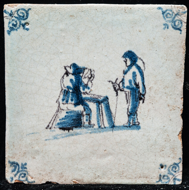 An early 17th C. Delft blue and manganese tile with two wool combers.