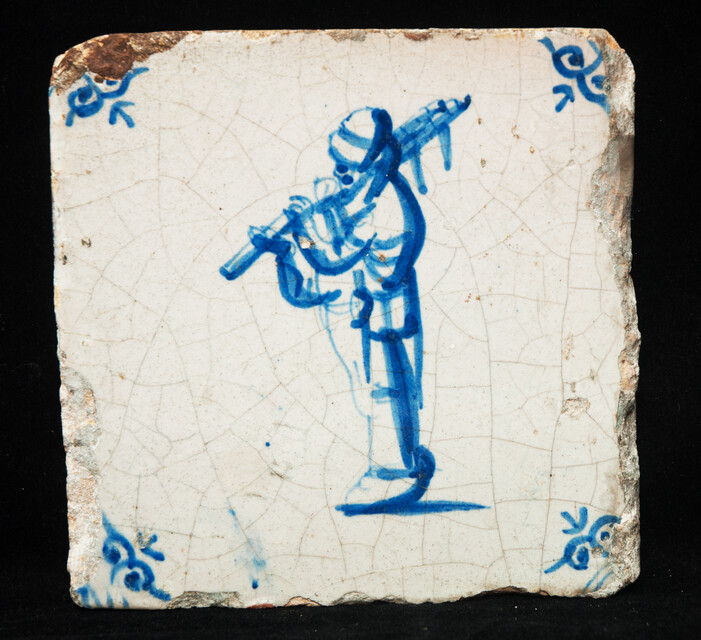 An early 17th C Delft blue tile with a bagpipe player.