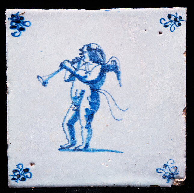 An early 17th C. Delft blue tile with an angel blowing a trumpet.