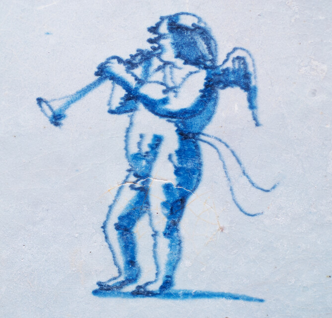 An early 17th C. Delft blue tile with an angel blowing a trumpet.