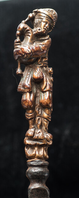 An early 17th Dutch knife with a brass handle showing a bag-pipe player.