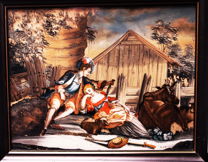 An eighteenth century reverse painting on glass. In a black frame.